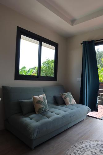 a couch in a living room with two windows at Aumihi Bungalow in HUH