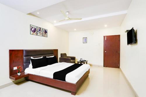 a bedroom with a bed and a television in it at Super Townhouse Gudivada Formerly Sistla in Gudivāda