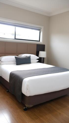 a large bed in a bedroom with a window at Renmark Holiday Apartments in Renmark