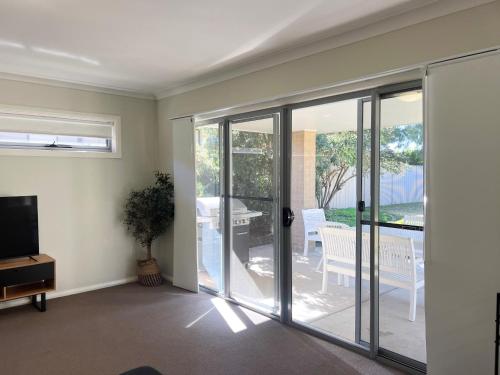 a living room with sliding glass doors and a patio at Boorooma Bliss in North Wagga