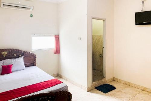 a bedroom with a bed and a walk in shower at Turuo Homestay Syariah Pringsewu Lampung Mitra RedDoorz in Margakaya