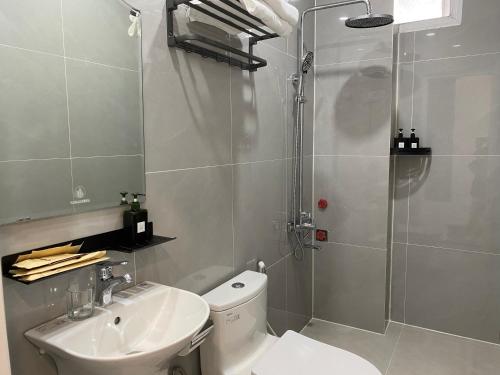 a bathroom with a shower and a toilet and a sink at Famille Hotel - Central hotel in Dalat in Xuan An