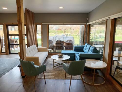 a living room with couches and tables and chairs at Rukawe Quillon in Quillón