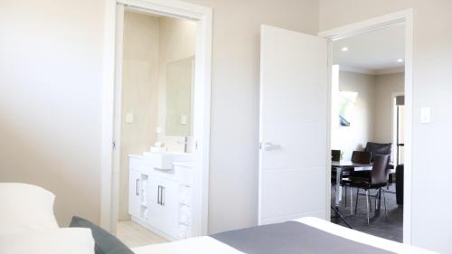 a white bathroom with a sink and a mirror at Renmark Holiday Apartments in Renmark