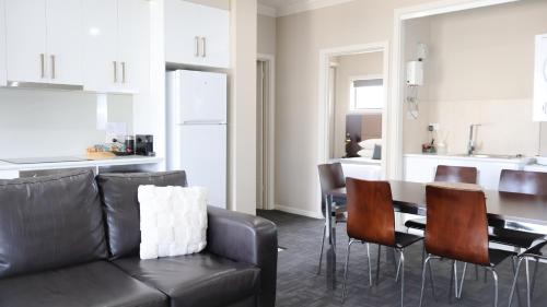 a living room with a black couch and a table at Renmark Holiday Apartments in Renmark