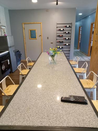 a table with a remote control on a counter with chairs at Rukawe Quillon in Quillón