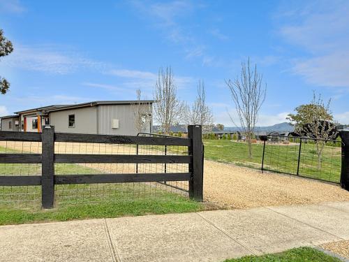 a fence in front of a field with a house at The Iron Pear - Pet Friendly with Country Views in Mansfield