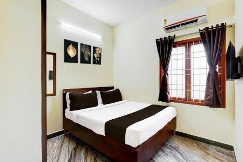 a bedroom with a bed and a window at Super Hotel O Thoraipakkam Chennai in Chennai