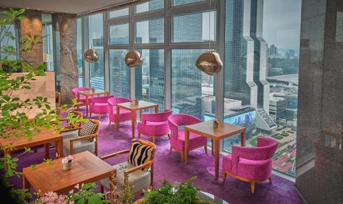 a restaurant with pink chairs and tables and windows at Park Hyatt Seoul in Seoul