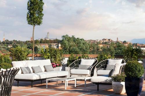 a group of white chairs sitting on a roof at Villa Ermellina Siena, a Tribute Portfolio Hotel in Siena