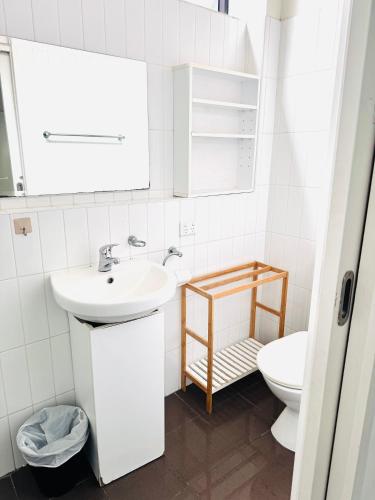 a white bathroom with a sink and a toilet at CarricHouse in Melbourne