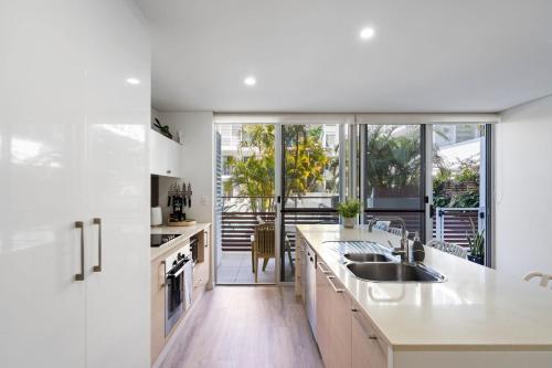 a kitchen with white counters and a large window at Waterline 102 in Forster