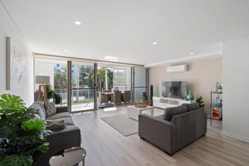 a living room with two couches and a tv at Waterline 102 in Forster