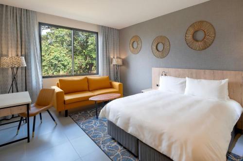 a hotel room with a bed and a chair at Protea Hotel by Marriott Ndola in Ndola