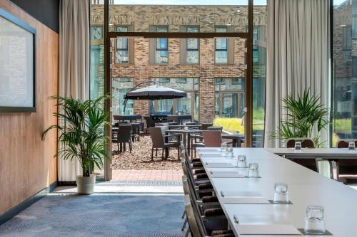 a restaurant with tables and chairs and large windows at Renaissance Amsterdam Schiphol Airport Hotel in Schiphol