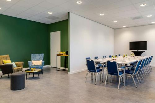 a conference room with a long table and chairs at Renaissance Amsterdam Schiphol Airport Hotel in Schiphol