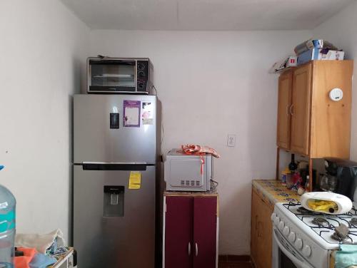 a kitchen with a microwave on top of a refrigerator at Casa de descanso con alberca y billar en Cuernavaca in Cuernavaca
