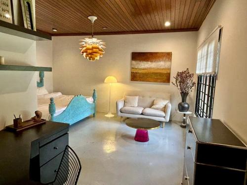 a living room with a couch and a bed at Chic Designer Master Bedroom in Shared Bungalow near LRT SS1 PJ in Petaling Jaya
