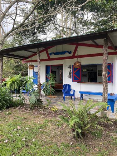 a house with a blue bench in front of it at Jicote cabañas in Paraíso