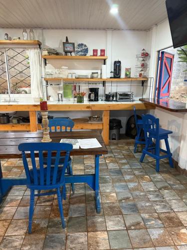 a dining room with blue chairs and a table at Jicote cabañas in Paraíso
