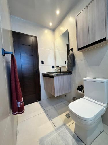 a bathroom with a toilet and a sink at Cómodo departamento in Cochabamba