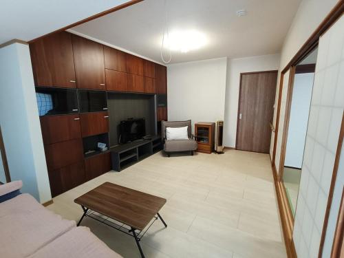 a living room with a couch and a table at させぼ旅の宿KawashimoEn in Sasebo