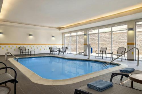 a pool in a hotel room with chairs and tables at Fairfield Inn & Suites by Marriott Bristol in Bristol