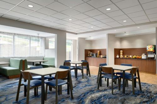 a waiting room with tables and chairs and a bar at Fairfield Inn & Suites by Marriott Bristol in Bristol