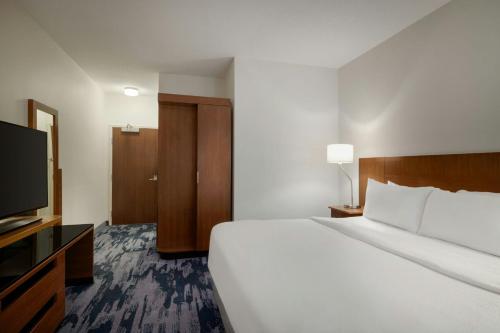 a hotel room with a bed and a flat screen tv at Fairfield Inn & Suites by Marriott Bristol in Bristol