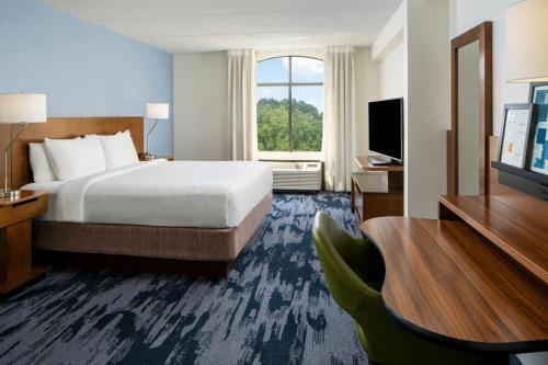 a hotel room with a bed and a television at Fairfield Inn and Suites Atlanta Airport South/Sullivan Road in Atlanta