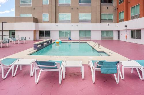 a swimming pool with chairs and a volley ball at Holiday Inn Express & Suites - Houston Westchase - Westheimer by IHG in Houston