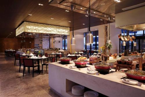 a restaurant with tables and chairs and a buffet at Novotel New Delhi Aerocity in New Delhi