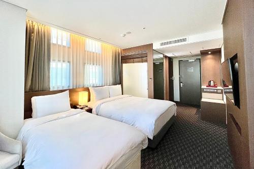 Postel nebo postele na pokoji v ubytování Ramada Encore by Wyndham Busan Station
