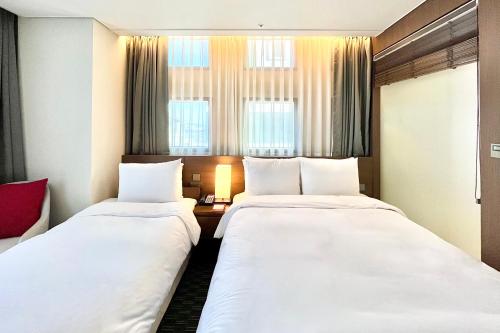 Postel nebo postele na pokoji v ubytování Ramada Encore by Wyndham Busan Station
