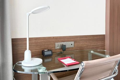 a glass table with a lamp on top of it at Ramada Encore by Wyndham Busan Station in Busan