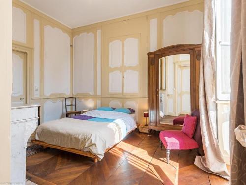 a bedroom with a bed and a mirror and a chair at Appartement charmant au cœur de Vesoul avec parking privé - FR-1-583-509 in Vesoul