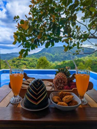 a table with food and two glasses of orange juice at Gold Field Villa in Koslanda