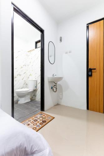 a bathroom with a sink and a toilet and a mirror at Escotel Journey Hotel Antapani in Bandung