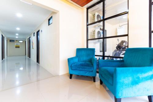 a hallway with two blue chairs in a hospital at Escotel Journey Hotel Antapani in Bandung