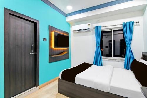 a bedroom with a bed and a tv and a door at Super Collection O Kolkata Near Dumdum Airport in kolkata