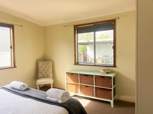 Un dormitorio con una cama y una ventana y una silla. en Rhoda Avenue Residence, en Wagga Wagga