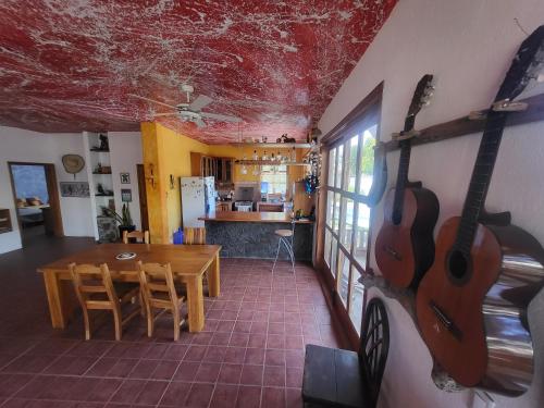 une pièce avec une table et deux guitares au mur dans l'établissement Casa de Muffin, à Puerto Ayora