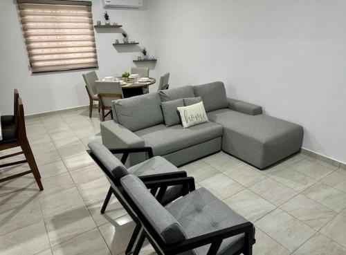a living room with a couch and chairs and a table at A haven for rest and relaxation in Puerto Morelos