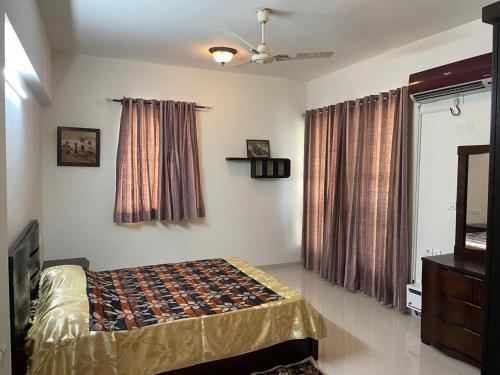 a bedroom with a bed and a ceiling fan at Urban Stay Service Apartments Oragadam in Oragadam
