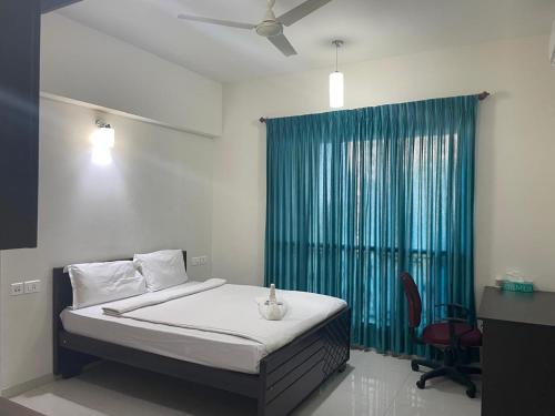 a bedroom with a bed and a green curtain at Urban Stay Service Apartments Oragadam in Oragadam