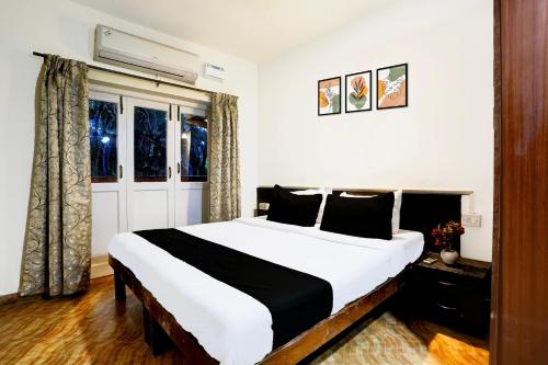 ein Schlafzimmer mit großem Bett und Fenster in der Unterkunft Collection O Holiday Street Calangute Formerly Shruti Resort in Goa
