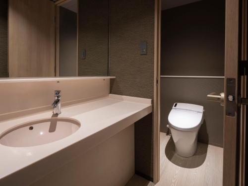 a bathroom with a sink and a toilet at KAMENOI HOTEL Arima in Kobe