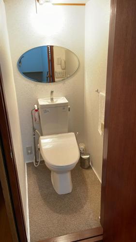 a bathroom with a white toilet and a mirror at Share House on the Hill in Yokohama