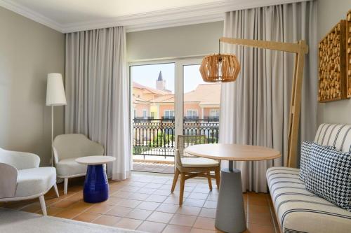 a living room with a couch and a table at Praia D'El Rey Marriott Golf & Beach Resort in Casal da Lagoa Seca