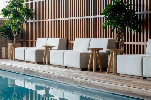 a row of white lounge chairs next to a swimming pool at Praia D'El Rey Marriott Golf & Beach Resort in Casal da Lagoa Seca